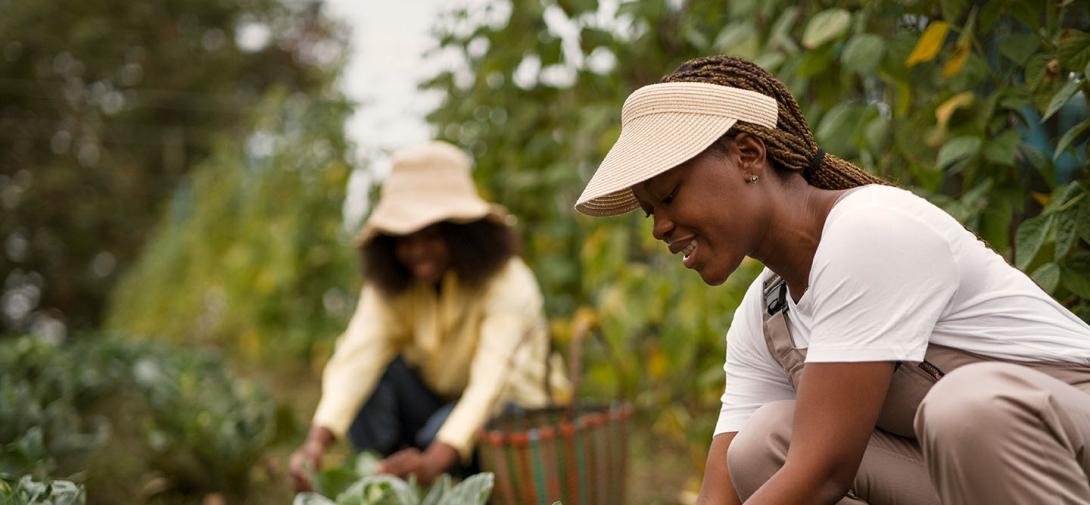 Dos mujeres agachadas aprendiendo sobre las técnicas agropecuarias